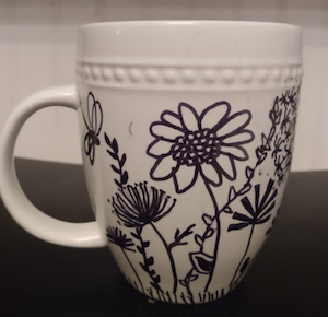 Image of a white mug with flowers drawn on it